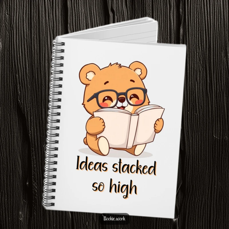 Funny bear with reading glasses, excitedly flipping through a large book, featured on the cover of a notebook.
